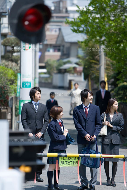踏み切りで電車の通過待ちをしている高校生たち の写真素材 イラスト素材 アマナイメージズ