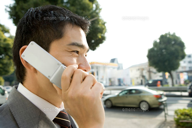 コンビニの前で携帯電話で話す男性 の写真素材 イラスト素材 アマナイメージズ