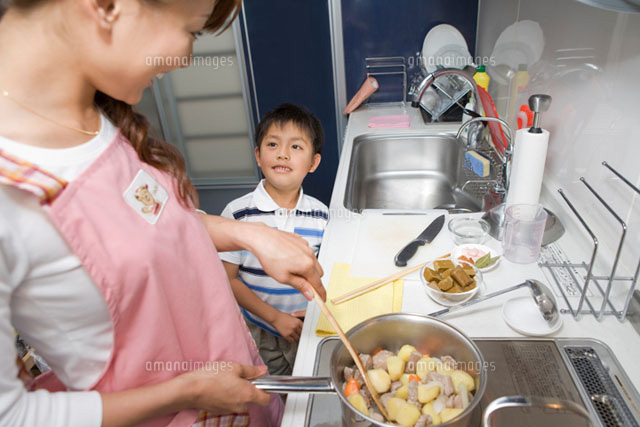 料理をしている母親に話しかける男の子 の写真素材 イラスト素材 アマナイメージズ