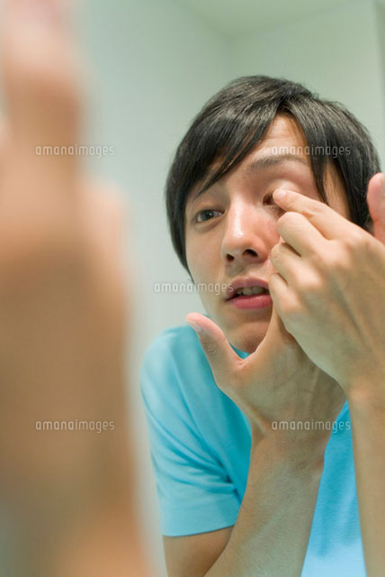 コンタクトレンズを装着する男性 の写真素材 イラスト素材 アマナイメージズ