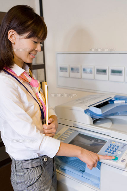 コピー機を操作している女性 の写真素材 イラスト素材 アマナイメージズ