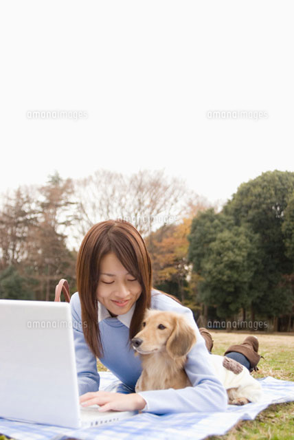 パソコンを操作する女性と犬 の写真素材 イラスト素材 アマナイメージズ