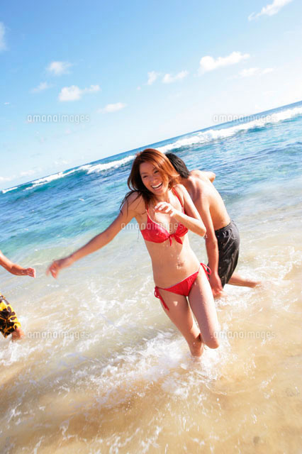 海で遊ぶ男女 の写真素材 イラスト素材 アマナイメージズ