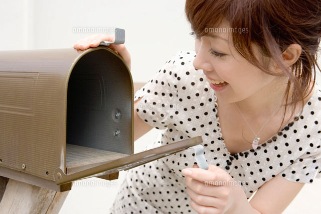 郵便受けを覗く女性 の写真素材 イラスト素材 アマナイメージズ