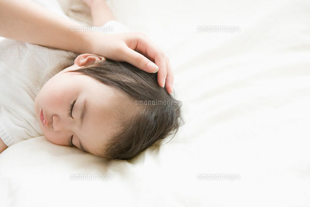 眠っている赤ちゃんを撫でるお母さんの手 の写真素材 イラスト素材 アマナイメージズ