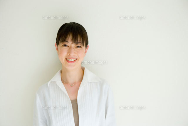 白い壁の前に立つ４０代女性 a の写真素材 イラスト素材 アマナイメージズ