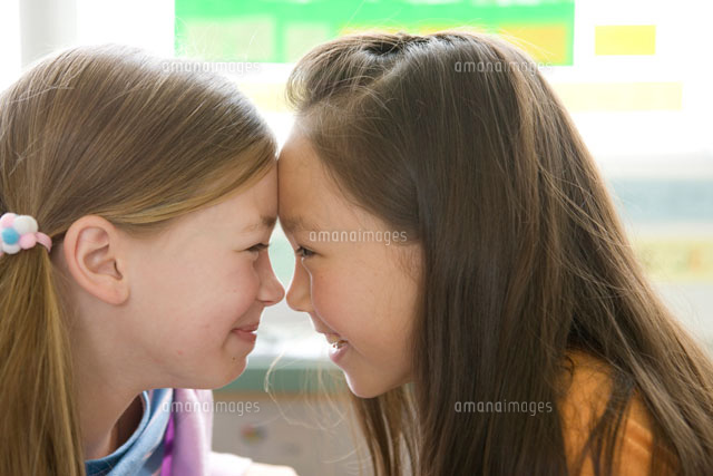 笑顔でおでこをつける女の子二人 の写真素材 イラスト素材 アマナイメージズ