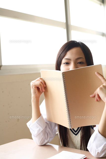 ノートで顔を隠す日本人の女子高校生 の写真素材 イラスト素材 アマナイメージズ