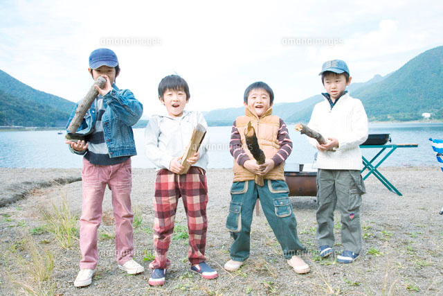 湖畔で枝を持って遊ぶ4人の男の子 の写真素材 イラスト素材 アマナイメージズ