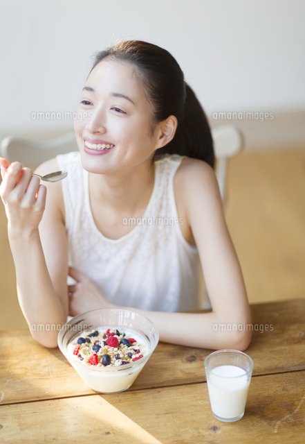 シリアルを食べる笑顔の女性 の写真素材 イラスト素材 アマナイメージズ