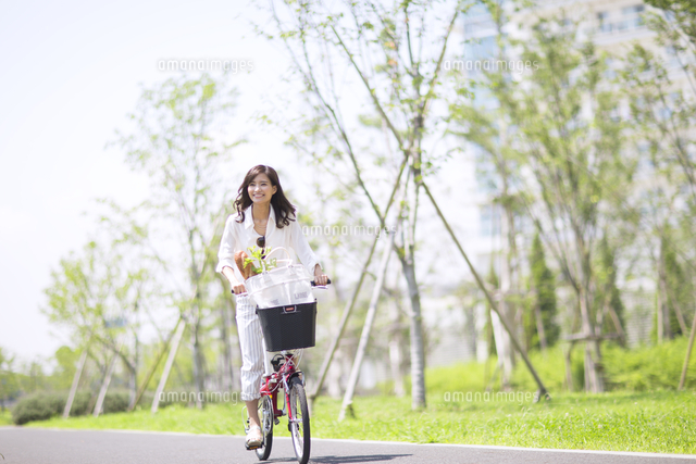 自転車で買い物をする女性[33000003907]の写真素材・イラスト素材 