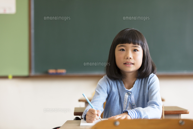 教室の椅子に座って勉強をする小学生の女の子 33000004174 の写真・イラスト素材