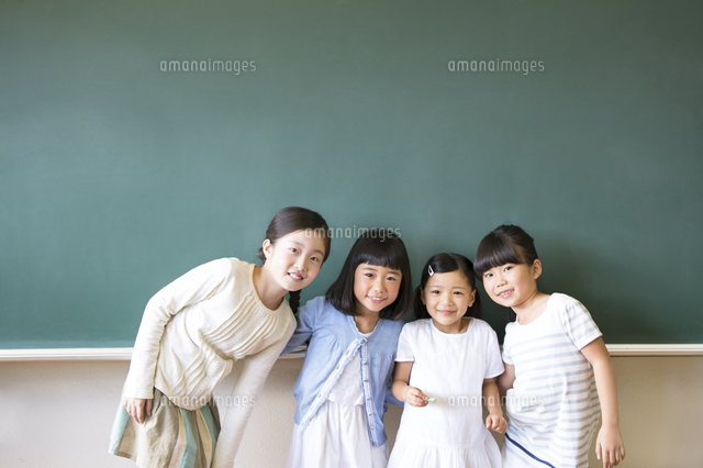 黒板の前に並んで立って笑う女の子4人 の写真素材 イラスト素材 アマナイメージズ