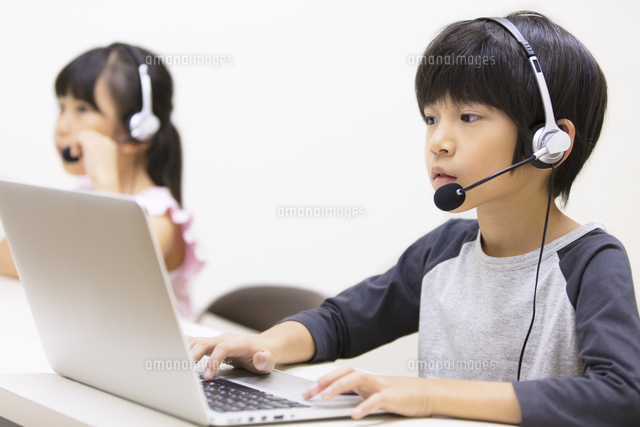 インカムを付けてパソコンを見る男の子と女の子 の写真素材 イラスト素材 アマナイメージズ
