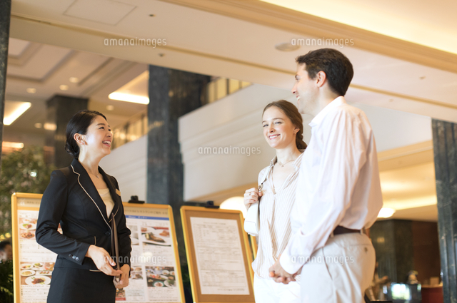 コンシェルジュと話しをする外国人の男女 の写真素材 イラスト素材 アマナイメージズ