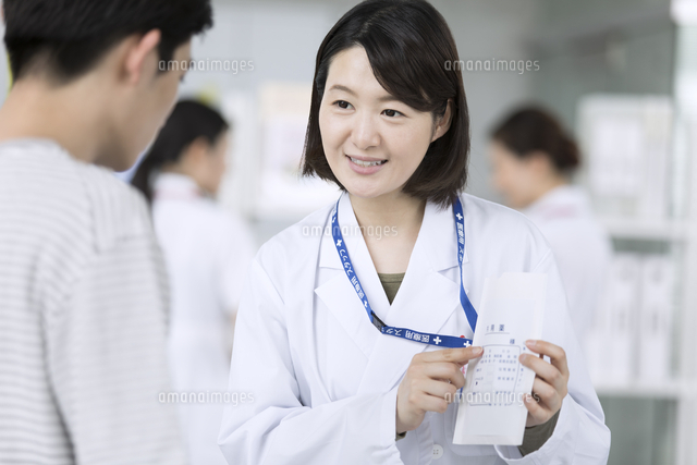受付で薬の説明をする女性薬剤師 の写真素材 イラスト素材 アマナイメージズ