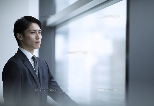 窓から遠くを見るビジネス男性 の写真素材 イラスト素材 アマナイメージズ