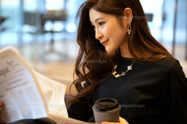 新聞を読む女性 の写真素材 イラスト素材 アマナイメージズ