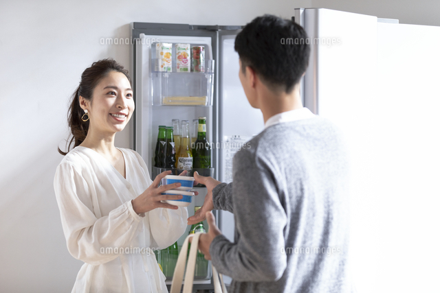 冷蔵庫に食料をしまう日本人夫婦 の写真素材 イラスト素材 アマナイメージズ