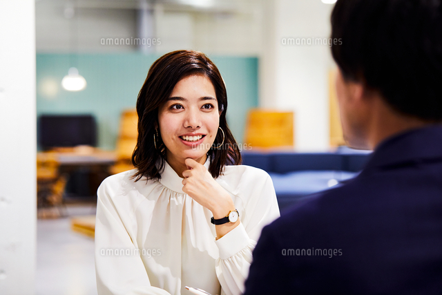 コワーキングスペースで会話する男女 の写真素材 イラスト素材 アマナイメージズ