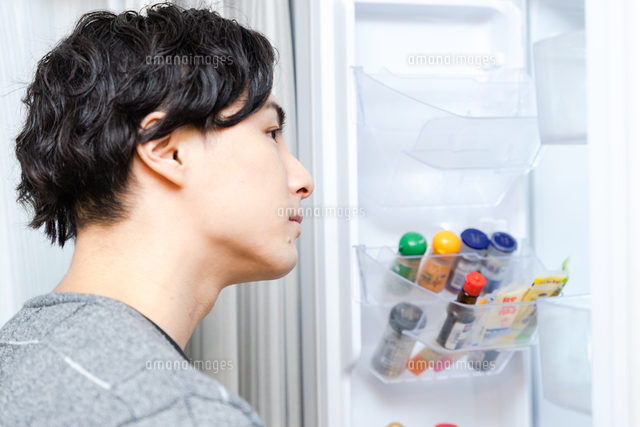 冷蔵庫の中を確認する30代の男性[65090004403]の写真・イラスト素材 
