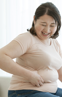 贅肉をつまむ太った女性 の写真素材 イラスト素材 アマナイメージズ