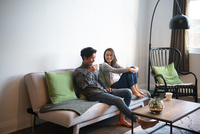 ソファに座ってくつろいでいるカップル の写真素材 イラスト素材 アマナイメージズ