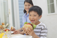 ハンバーガーを食べる男の子 の写真素材 イラスト素材 アマナイメージズ