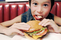 ハンバーガーを食べる男の子 の写真素材 イラスト素材 アマナイメージズ