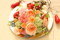 お皿に飾られたオレンジの花のフラワーアレンジメント[21002003276]の